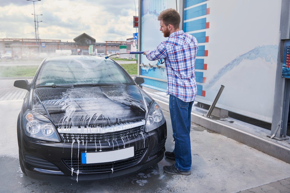 hombre limpiando su coche en holacarwash